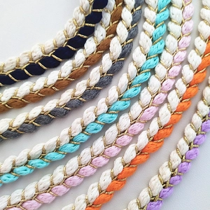 Close-up of colorful braided crossbody bag straps with gold metallic thread accents