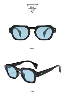 Détails de lunettes de soleil ovales avec monture noire, verres bleus et rivets