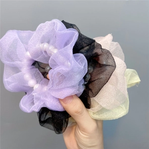 Detail von bunten Organza-Haargummis mit weißen Kunstperlen für stilvolle Frisuren