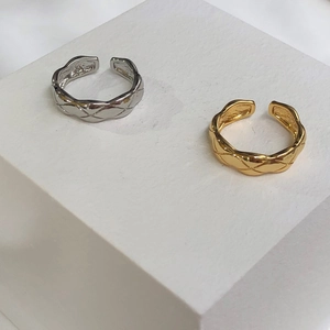 Detail of silver and gold open rings featuring a classic geometric diamond quilted pattern