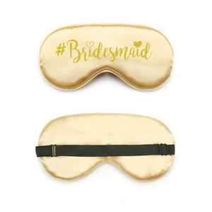 Close-up of golden satin bridesmaid sleep mask with adjustable strap and glitter text