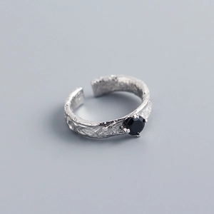 Macro shot of silver ring with hammered texture and black zircon in a claw setting