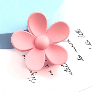 Detail view of large matte pink flower hair claw clip with frosted resin finish