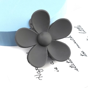 Close-up of a matte dark grey flower hair claw clip with detailed five-petal design