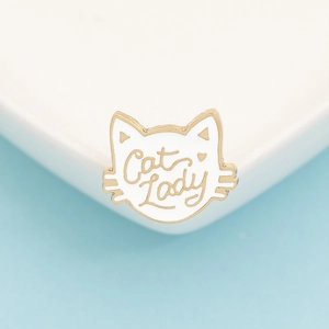 Detailed view of enamel cat head brooch with white finish and Cat Lady golden lettering