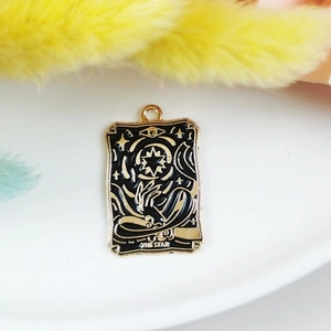 Macro shot of dark series black and gold enamel tarot pendant with The Star design