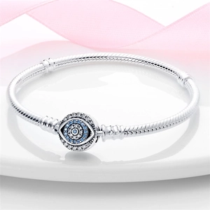 Detailed view of silver snake chain bracelet featuring a blue Evil Eye charm with zircons