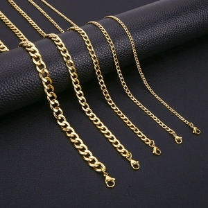 Five gold stainless steel Cuban link chains in various widths on black background