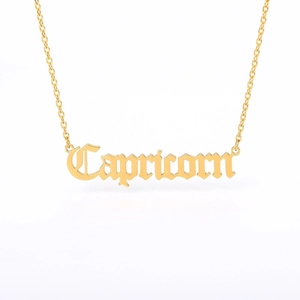 Detailed macro view of a gold Capricorn necklace pendant with gothic letter design
