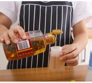 Detail showing oil poured into a transparent silicone bottle with measurement scales