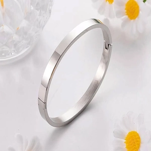 Close-up of polished silver titanium steel bangle showing hinge and secure clasp detail
