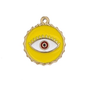 Detailed macro view of gold evil eye charm with yellow enamel finish and wavy edge