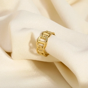 Macro view of 18K gold plated stainless steel pig nose ring on white satin fabric