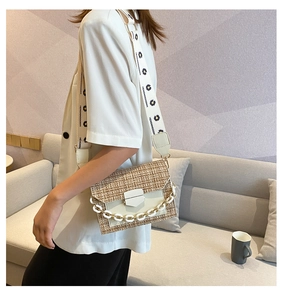 Detail of tweed weave shoulder bag featuring daisy strap and chunky chain strap