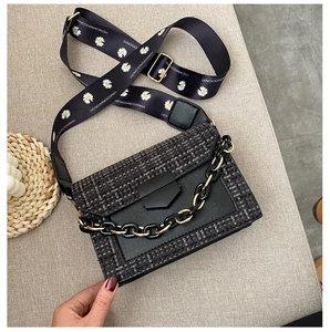 Detail of tweed crossbody bag with daisy strap and chunky black and gold chain links