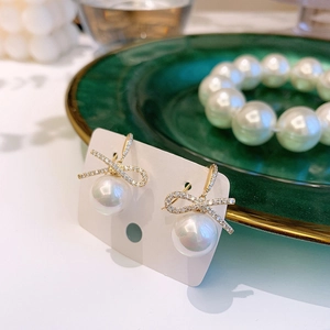Elegant gold bow earrings with sparkling zircon crystals and white round pearls for women