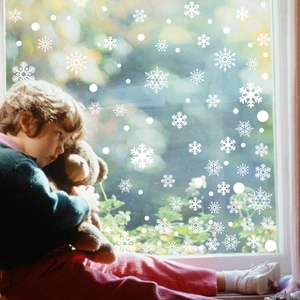 Winter-Fensteraufkleber mit weißen Schneeflocken und Kind mit Teddybär als Dekoration