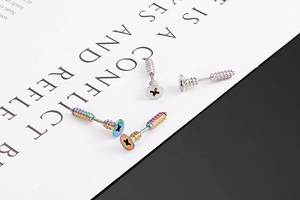 Detailed close-up of creative screw shaped stainless steel studs in silver and rainbow colors