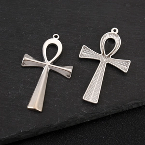 Detailed view of silver Ankh cross pendants with smooth and embossed textures on stone