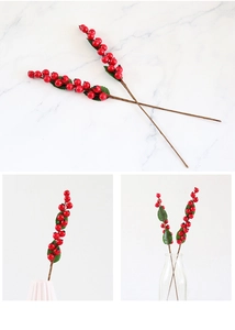 Detailed view of artificial red holly berries with green leaves in a stylish vase