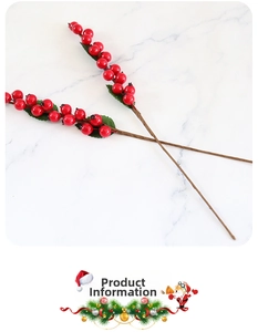Close-up of artificial red berry stems with green leaves on marble surface