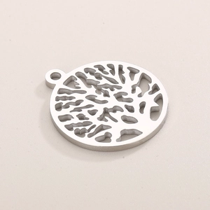 Detailed view of silver tree of life cutout pendant in polished stainless steel
