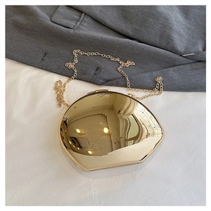 Detailed view of an irregular gold metallic clutch bag with a sleek mirror finish and chain