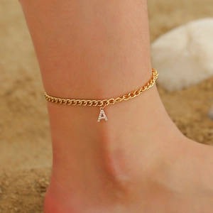 Bracelet de cheville doré étincelant avec lettre A en diamant porté par un mannequin