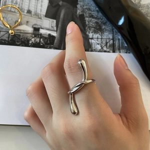 Macro detail of minimalist silver twisted knot ring on finger for fashion look