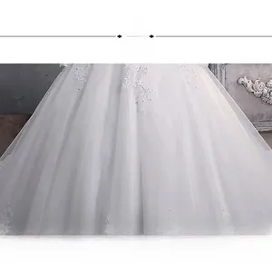 Detailed close-up of white bridal gown skirt with delicate floral lace embroidery and sequins