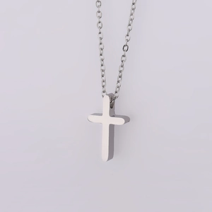 Macro detail of high-polish mirror finish stainless steel cross pendant on fine O-chain
