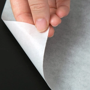 Non-stick white silicone baking paper for oven cooking with serrated edge and thin texture