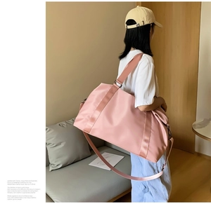 Pink waterproof fitness bag with wide handles and adjustable strap for short trips