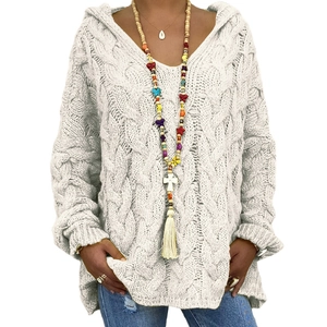 Close-up of white cable knit texture and hooded V-neck detail on oversized sweater