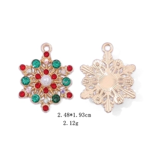 Detailed view of snowflake earrings with red and green rhinestones and a white pearl