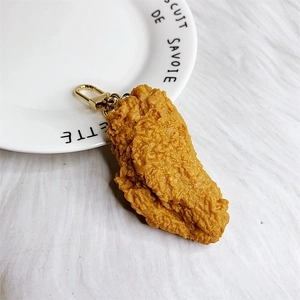 Macro shot of realistic fried chicken keychain with crispy texture and golden metal clasp