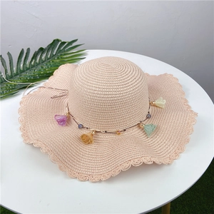 Beige wide-brim straw hat with wavy edges and colorful macaron flower charms