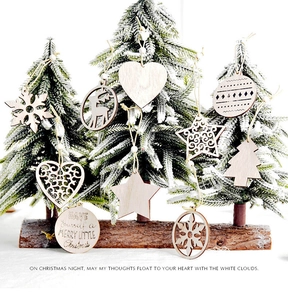 Close-up of laser-cut wooden snowflake and reindeer ornaments on a mini Christmas tree