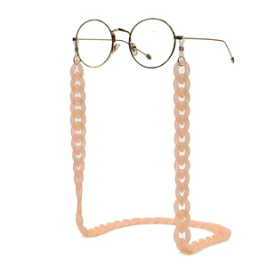 Matte pink acrylic eyeglass chain with gold hooks on white background