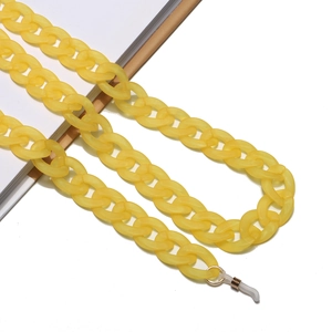 Frosted yellow acrylic eyewear chain with adjustable loops on laptop edge