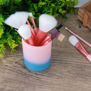 Set of 12 rose pink makeup brushes with white bristles in a gradient storage cylinder