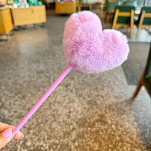 Close-up of a cute purple pen featuring a fluffy heart-shaped plush ball top decoration