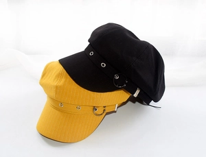 Detail of vintage octagonal newsboy caps with decorative leather straps and metal eyelets