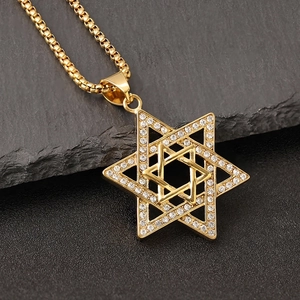 Iced-out Star of David pendant necklace in gold-plated titanium steel on rock surface