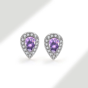 Macro detail of pear-cut purple gemstone earrings with silver halo and small white crystals