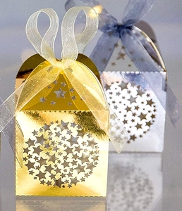 Macro view of laser-cut star patterns on shiny gold and silver festive gift boxes