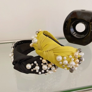 Detail of knotted fabric headbands with elegant pearls and silver beads in black and yellow