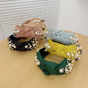 Detail of knotted satin headbands in multiple colors with pearl and bead embellishments