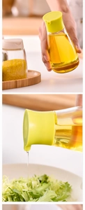 Détail macro du distributeur d'huile en verre étanche versant de l'huile sur une salade
