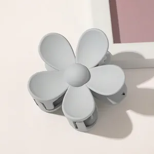 Close-up of a matte grey five-petal flower hair claw clip with a textured finish